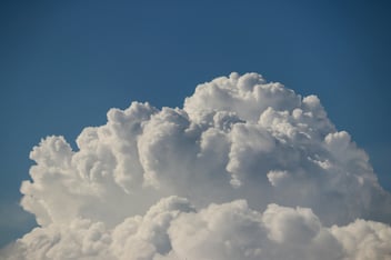 White cloud in the blue sky symbolizing the scalability and flexibility of cloud computing in solutions such as Adaptive Warehouse.